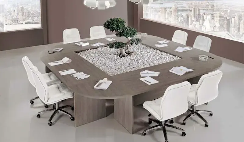 چیدمان خلاقانه لوازم روی میز کنفرانس با گل طبیعی و وسایل اداری لوکس